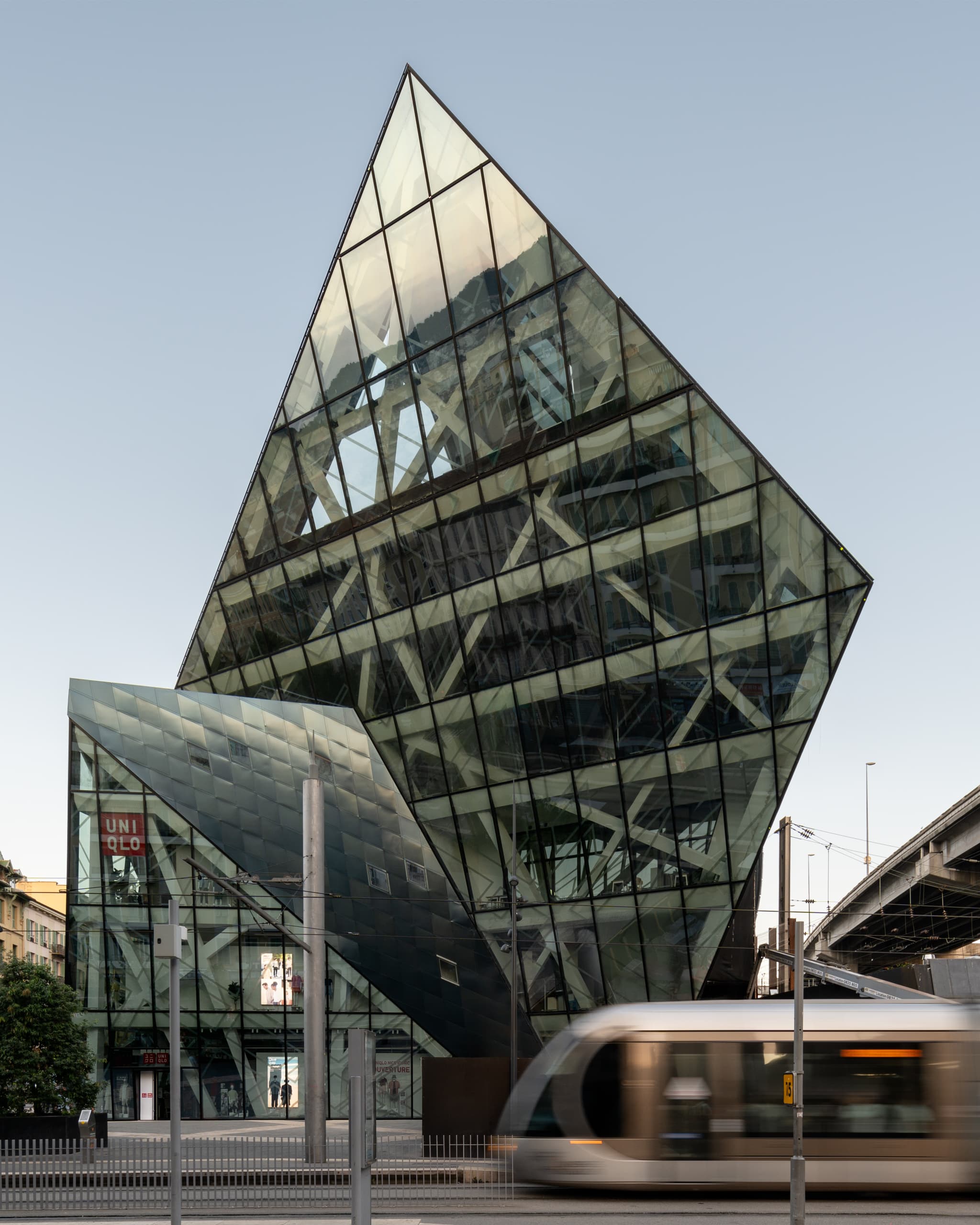 Exterior view, contemporary urban building, Iconic Nice with passing tram, by Andrius Gudelis