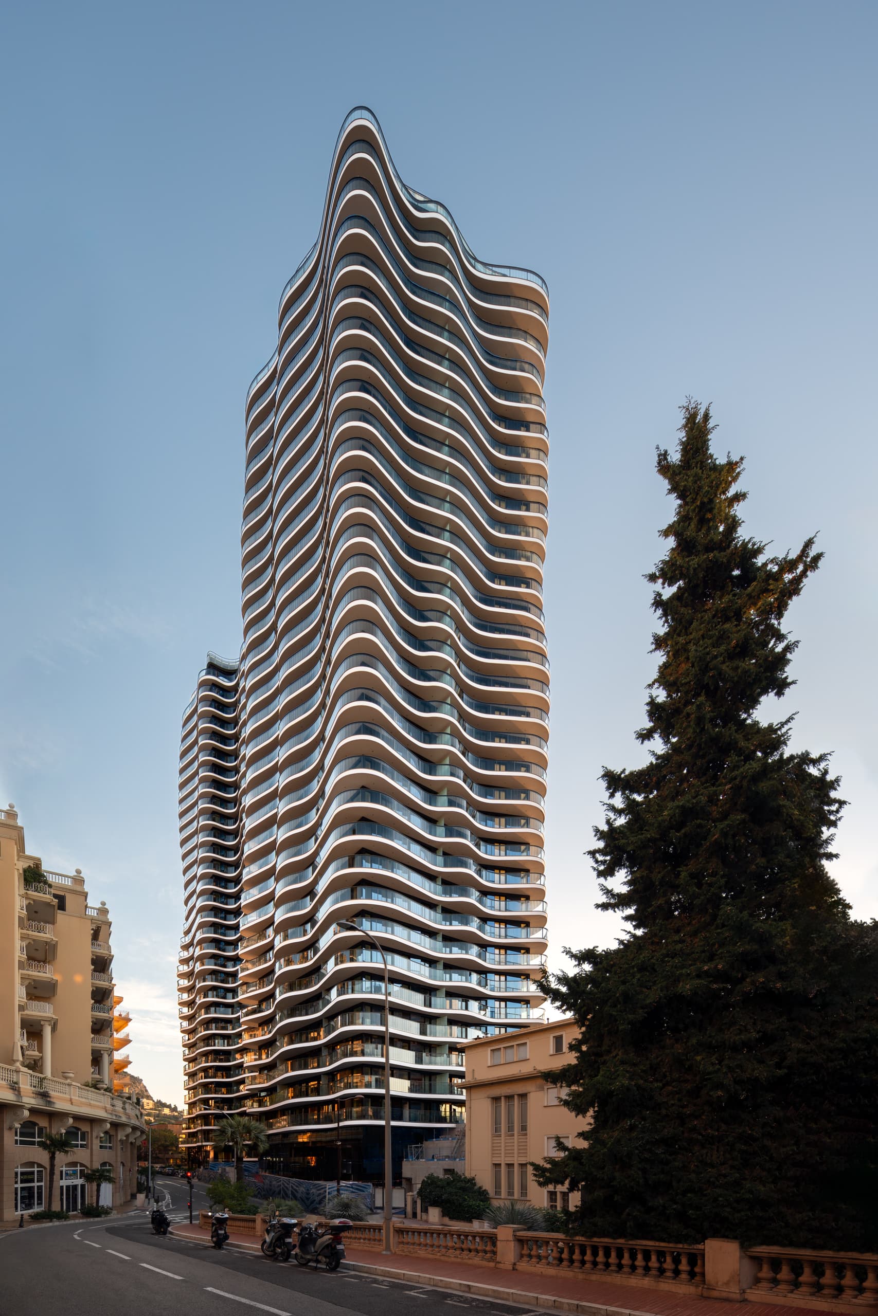 Skyscraper Testimonio II, Monaco, wavy exterior view at dusk, by Andrius Gudelis